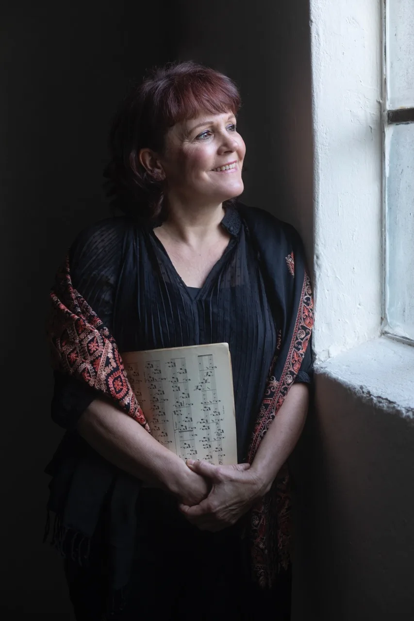 Natasja Douma bij het venster, met bladmuziek in de hand